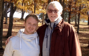 Former NHL coach and Legacy Donor Paul Theriault and son smile in a park
