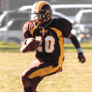 Legacy Donor Corey Davis in his high school uniform running with the football