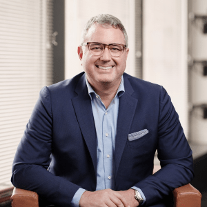 Concussion Legacy Foundation Board of Directors member Erik Smith smiles in a suit